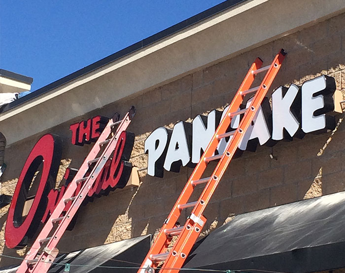 Seamless Signs Services working on installing sign